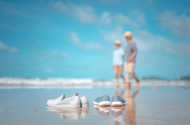 Früheren Ruhestand vorbereiten: Senioren spazieren am Strand.