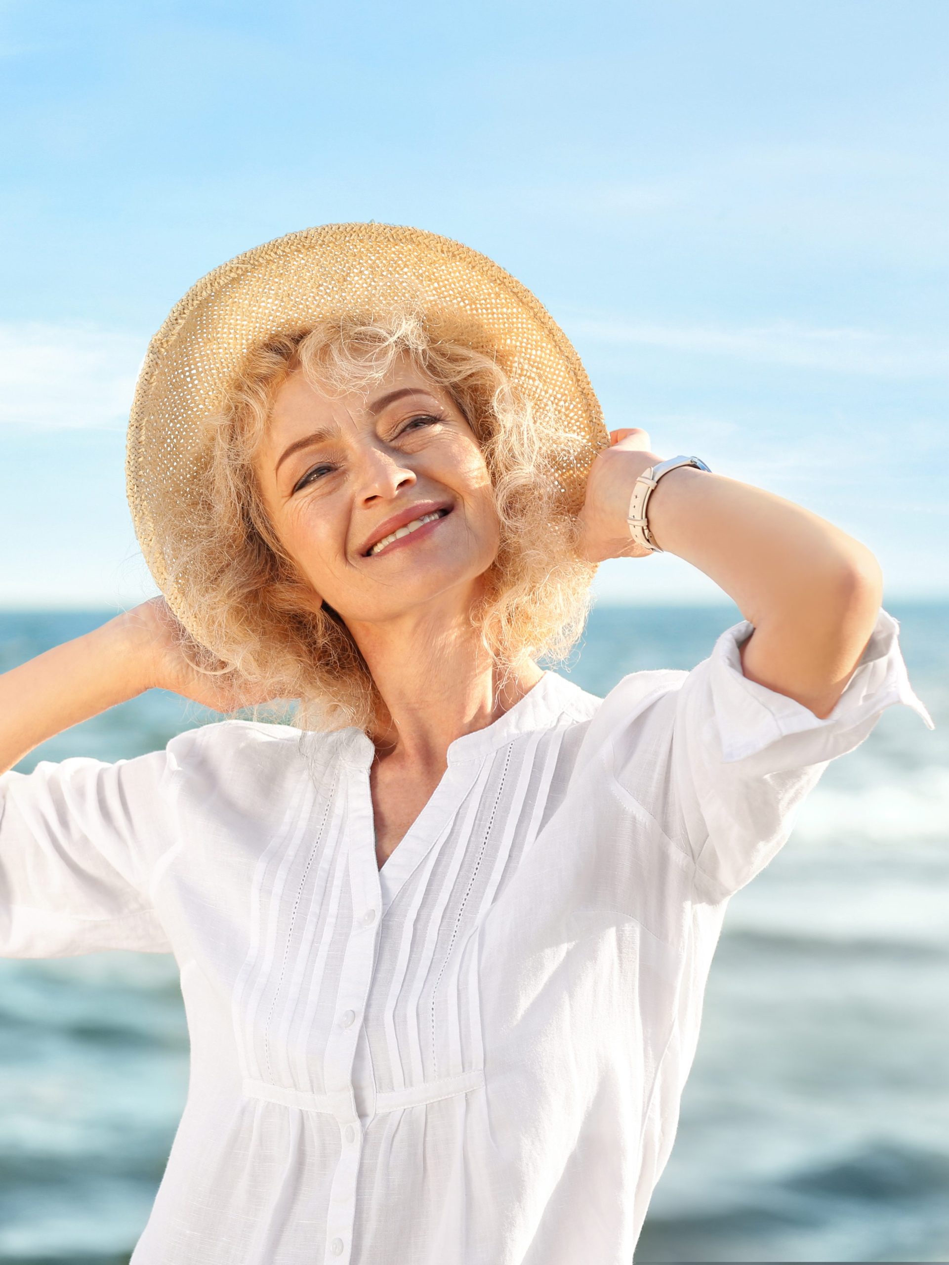 Frau am Strand mit Sonnenhut